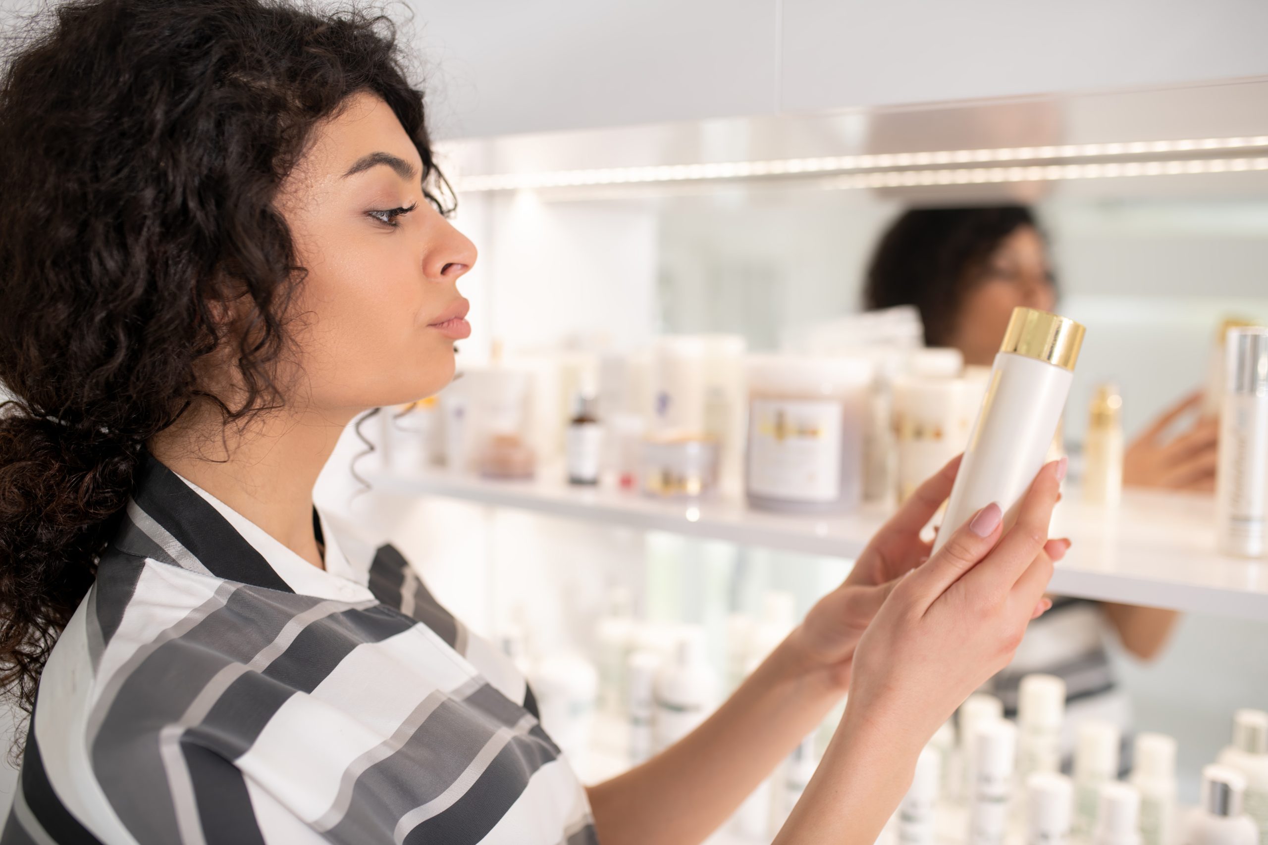 a lady checking the ingredients of a skincare product