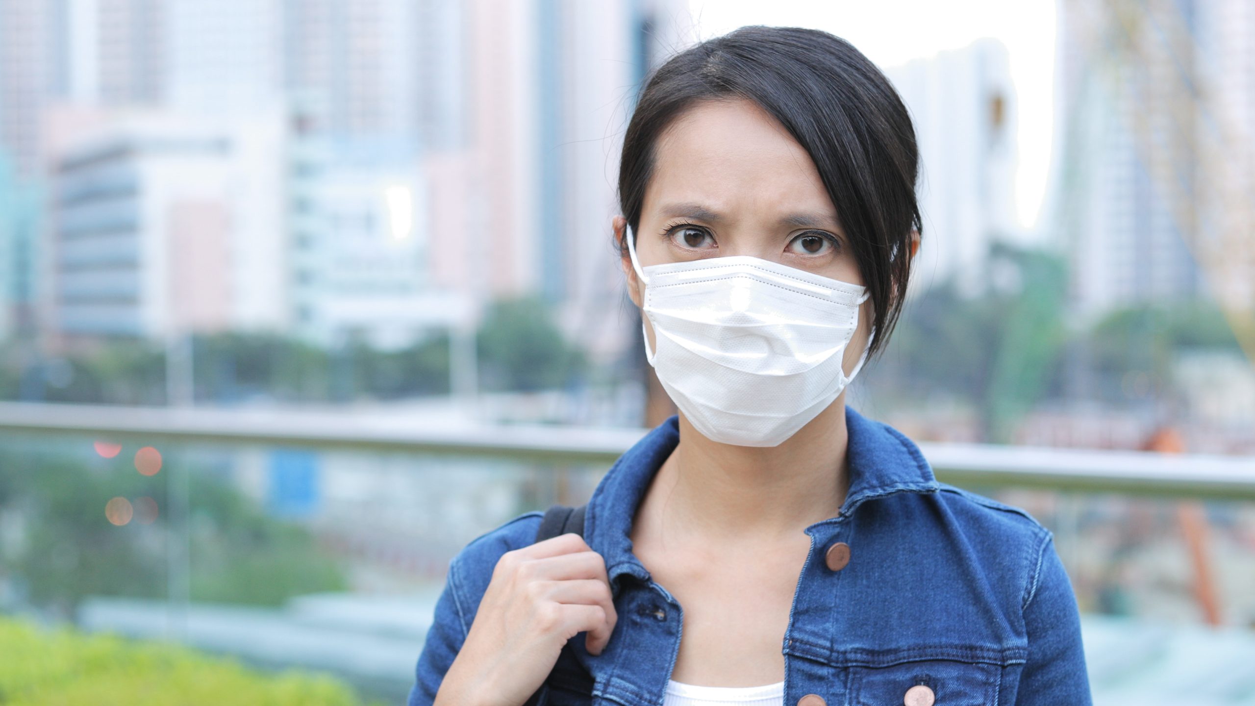 Woman wearing face mask in the city air pollution affect skin